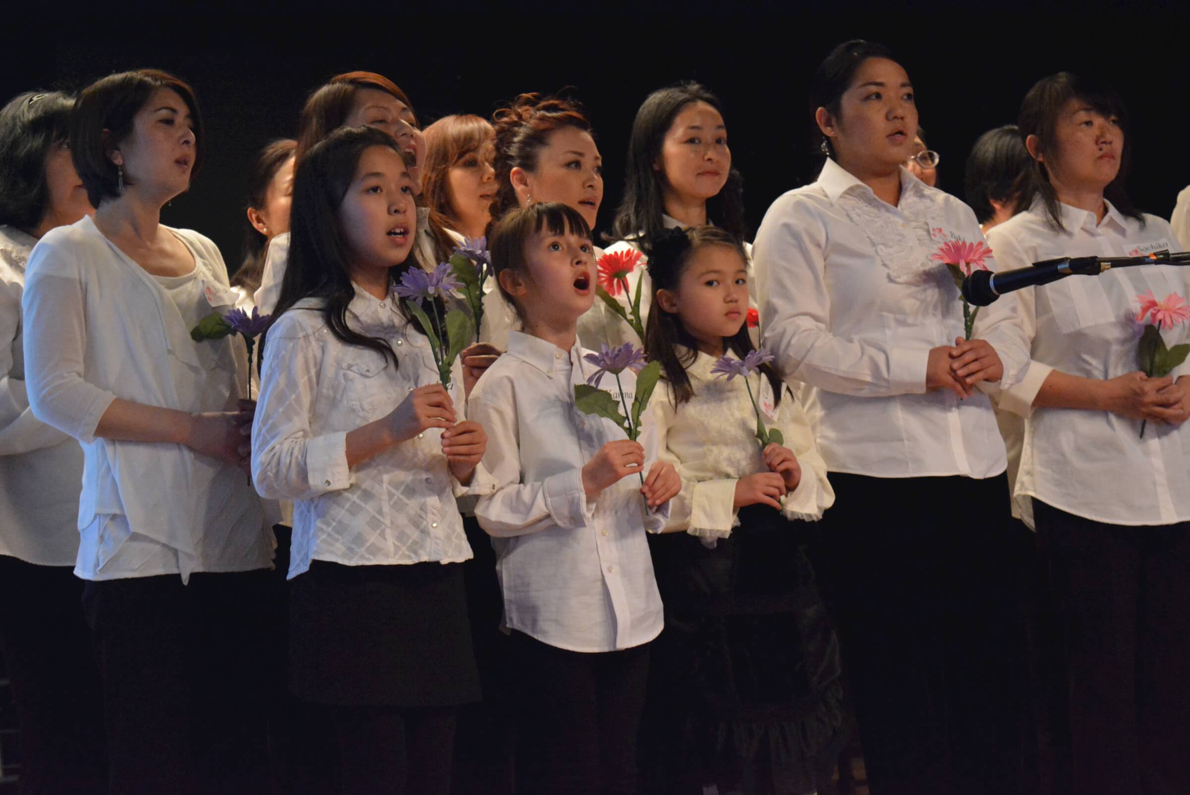 Members of the Sakura Chorus Mile High , singing “Hana wa saku” (“Flowers Will Bloom”)